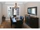Formal dining area features a modern chandelier, shuttered windows, and dark wood furniture at 3841 Falls Cir, Carmel, IN 46033