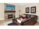 Cozy living room with a stone fireplace, leather seating, ottoman, and stylish decor at 3841 Falls Cir, Carmel, IN 46033