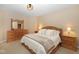Bright main bedroom with a queen bed, side tables, lamps, and a dresser with decorative mirror at 3841 Falls Cir, Carmel, IN 46033