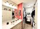 Bathroom vanity with bright red accent wall and view to walk-in closet with seating area at 430 N Park Ave # 302, Indianapolis, IN 46202