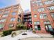 Wide view of a brick apartment building with multiple floors, balconies, and a red awning over the entrance at 430 N Park Ave # 302, Indianapolis, IN 46202