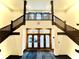 Elegant staircase with dark wood railings and a view of the building's entrance at 430 N Park Ave # 302, Indianapolis, IN 46202