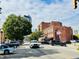 Street view of the city, featuring brick buildings with colorful murals, a tree-lined street and parked cars at 430 N Park Ave # 302, Indianapolis, IN 46202