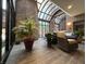 Sunroom with brick walls and a glass ceiling with comfortable armchairs at 430 N Park Ave # 302, Indianapolis, IN 46202