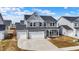 Two-story home with a covered front porch, a three car garage and coordinated landscaping at 526 Carroll St, New Whiteland, IN 46184