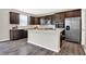 Kitchen with stainless steel appliances, center island, dark wood cabinets, and hardwood floors at 526 Carroll St, New Whiteland, IN 46184