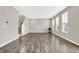 Open-concept living room with beautiful wood-look floors, large windows, and a staircase at 526 Carroll St, New Whiteland, IN 46184