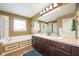 Bright bathroom featuring double sinks, soaking tub, and a large mirror at 538 Cyclamen Chase, Westfield, IN 46074