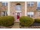 Close-up of the brick front entrance with red door, bushes, landscaping, and a large arched window at 538 Cyclamen Chase, Westfield, IN 46074