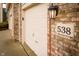 Close-up of a three-car garage, address number, exterior brick, and an outdoor light fixture at 538 Cyclamen Chase, Westfield, IN 46074