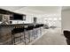 Finished basement featuring a bar with seating, dark cabinetry, and view to another living area with natural light at 565 Old Ashbury Rd, Westfield, IN 46074