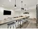 Stylish basement bar area featuring a countertop with bar stools, pendant lights, and a flat-screen television at 565 Old Ashbury Rd, Westfield, IN 46074