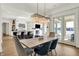 Open dining room with modern chandelier and view into the kitchen and living room at 565 Old Ashbury Rd, Westfield, IN 46074
