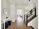 Bright foyer with hardwood floors, staircase with black railing, and elegant console table at 565 Old Ashbury Rd, Westfield, IN 46074