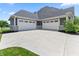 Spacious three-car garage featuring white doors and a large concrete driveway for ample parking at 565 Old Ashbury Rd, Westfield, IN 46074