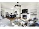 Bright, open living room featuring a modern fireplace, stylish decor, and seamless flow into the gourmet kitchen at 565 Old Ashbury Rd, Westfield, IN 46074