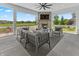 Relaxing covered patio with stone fireplace, ceiling fan, and comfortable outdoor seating at 565 Old Ashbury Rd, Westfield, IN 46074
