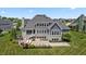 Stunning rear exterior with a spacious patio, outdoor kitchen, hot tub, and bocce ball court at 565 Old Ashbury Rd, Westfield, IN 46074