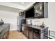 Modern wet bar with black cabinetry, stainless steel appliances, and stylish countertop accessories at 565 Old Ashbury Rd, Westfield, IN 46074
