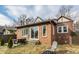 Backyard of brick home with a patio, seating, well-kept lawn, trees, and a small landscaped area at 6189 Primrose Ave, Indianapolis, IN 46220