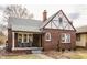 Quaint brick Tudor-style home featuring a cozy front porch and well-maintained exterior at 6189 Primrose Ave, Indianapolis, IN 46220