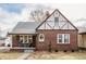 Charming brick Tudor-style home with a covered front porch and manicured landscaping at 6189 Primrose Ave, Indianapolis, IN 46220