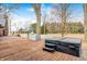 Backyard wooden deck featuring a hot tub and steps surrounded by trees and a blue sky at 690 N 600 W, Lebanon, IN 46052