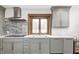 Modern kitchen featuring sleek gray cabinetry, stainless steel appliances, and a bright, window-lit sink area at 690 N 600 W, Lebanon, IN 46052