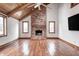 Bright living room with a brick fireplace, wood-beamed ceiling, and hardwood floors, creating a warm and inviting atmosphere at 690 N 600 W, Lebanon, IN 46052