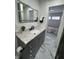 Modern bathroom boasts granite countertop, an illuminated mirror and updated fixtures at 7406 E 33Rd St, Indianapolis, IN 46226
