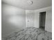 Fresh bedroom with stylish marble-look flooring, white walls, and a door to another room at 7406 E 33Rd St, Indianapolis, IN 46226