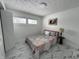Cozy bedroom with large windows, white walls and a statement floral bedspread, flooded with natural light at 7406 E 33Rd St, Indianapolis, IN 46226