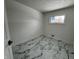 Bright bedroom featuring marble-style floors, a window letting in natural light, and neutral wall paint at 7406 E 33Rd St, Indianapolis, IN 46226