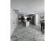 Bright kitchen with new marble tile floor, island, stainless steel appliances and dark backsplash at 7406 E 33Rd St, Indianapolis, IN 46226