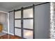 Attractive barn door with frosted glass panels and dark trim on hardwood floors at 790 N 14Th St, Noblesville, IN 46060