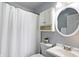 A clean bathroom with a vanity, a white sink, an oval mirror, and a shower with a white shower curtain at 790 N 14Th St, Noblesville, IN 46060