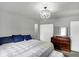 Well-lit main bedroom featuring a queen bed, storage closet, and dark wood dresser at 790 N 14Th St, Noblesville, IN 46060