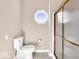 Bathroom featuring a toilet and walk-in shower with glass doors and unique octagon-shaped window at 8717 Vintner Ct, Indianapolis, IN 46256