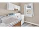 Functional laundry room with sink, washer, dryer, and storage cabinets at 8717 Vintner Ct, Indianapolis, IN 46256