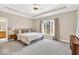 Spacious main bedroom with tray ceilings, neutral walls, and a large window at 8717 Vintner Ct, Indianapolis, IN 46256