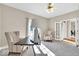 A well-lit office with a ceiling fan, chairs, a large window, and neutral walls at 8717 Vintner Ct, Indianapolis, IN 46256
