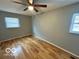 Bedroom with hardwood flooring, neutral walls, ceiling fan, and natural light streaming through two windows at 8738 Montery Ct, Indianapolis, IN 46226