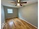 Cozy bedroom featuring hardwood floors, neutral walls, ceiling fan, and a window with views of the outdoors at 8738 Montery Ct, Indianapolis, IN 46226