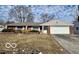 Charming brick ranch-style home with an attached two-car garage and a well-maintained front lawn at 8738 Montery Ct, Indianapolis, IN 46226
