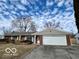 Charming brick home with a two-car garage, well-kept lawn, and mature trees at 8738 Montery Ct, Indianapolis, IN 46226
