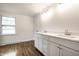 Bathroom featuring double sinks with modern fixtures, white cabinetry, and wood flooring at 8888 Cholla Rd, Indianapolis, IN 46240