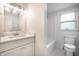 Bathroom featuring a white vanity, a tub, and a toilet, all illuminated with modern lighting at 8888 Cholla Rd, Indianapolis, IN 46240