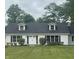 Charming white brick home featuring dormer windows, black shutters, and a lush green lawn at 8888 Cholla Rd, Indianapolis, IN 46240