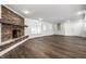 Bright living room showcasing a cozy brick fireplace, vinyl flooring, and a door leading to the outdoor space at 8888 Cholla Rd, Indianapolis, IN 46240