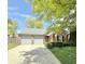 Charming red brick home with a well-maintained lawn, mature trees, and an attached two-car garage at 9788 Pine Ridge North Dr, Fishers, IN 46038
